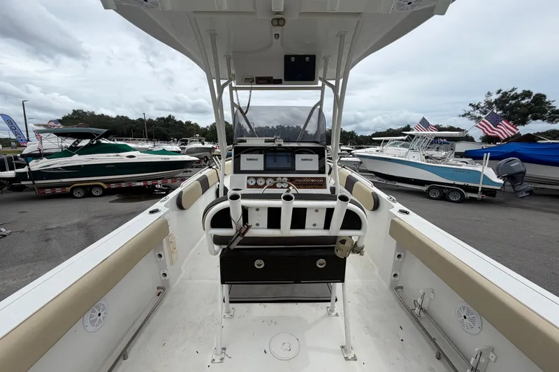 Slide: The Image of 2021 Key Largo 2650WI boat interior with helm, surrounded by other boats in a marina. - 10