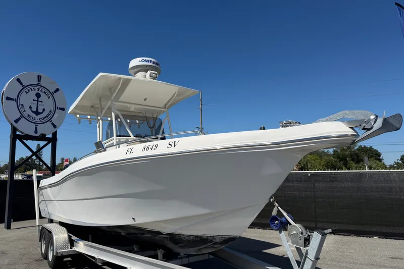 The Image of 2021 Key Largo 2650WI boat on trailer under clear blue sky. - 0
