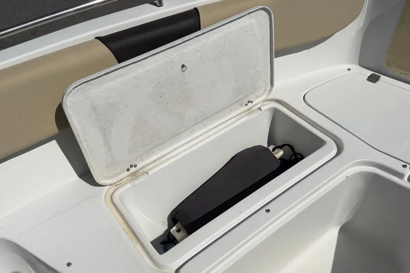 Slide: The Image of Open storage compartment on a 2021 Key Largo 2650WI boat, featuring a cushioned seat. - 49