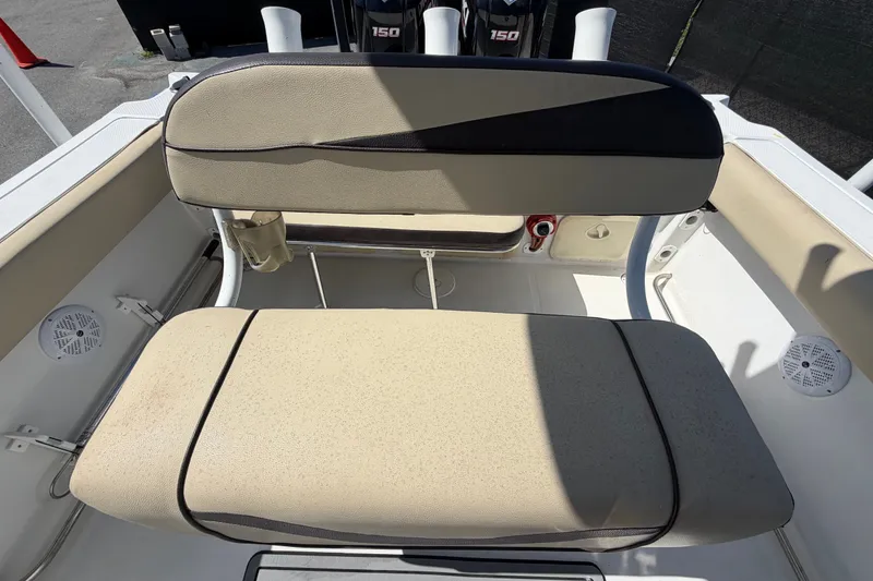 Slide: The Image of 2021 Key Largo 2650WI boat seating area with beige cushions and storage compartments. - 67