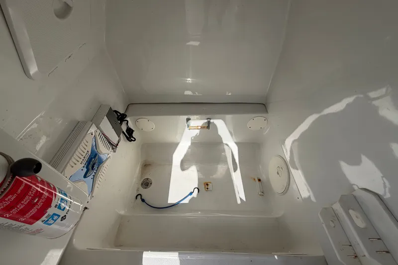 Slide: The Image of 2021 Key Largo 2650WI boat interior with equipment and storage compartments. - 65