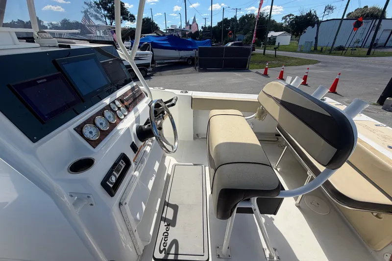 Slide: The Image of 2021 Key Largo 2650WI boat interior with steering console and seating area. - 23