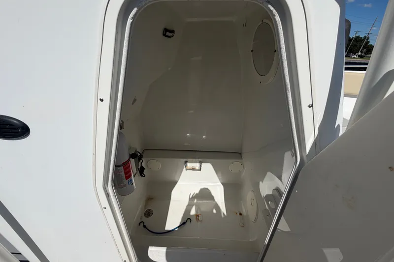 Slide: The Image of 2021 Key Largo 2650WI boat storage compartment with fire extinguisher. - 63