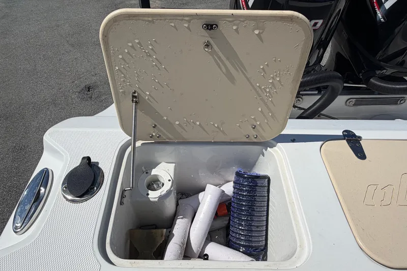 Slide: The Image of Open storage compartment on 2021 Key Largo 2650WI boat with hoses and accessories. - 77