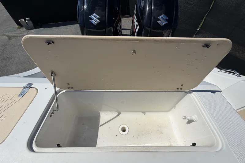 Slide: The Image of Open storage compartment on a 2021 Key Largo 2650WI boat with Suzuki engines. - 75