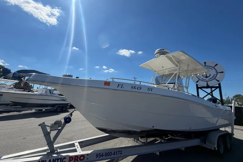 Slide: The Image of 2021 Key Largo 2650WI boat on trailer under clear blue sky. - 14