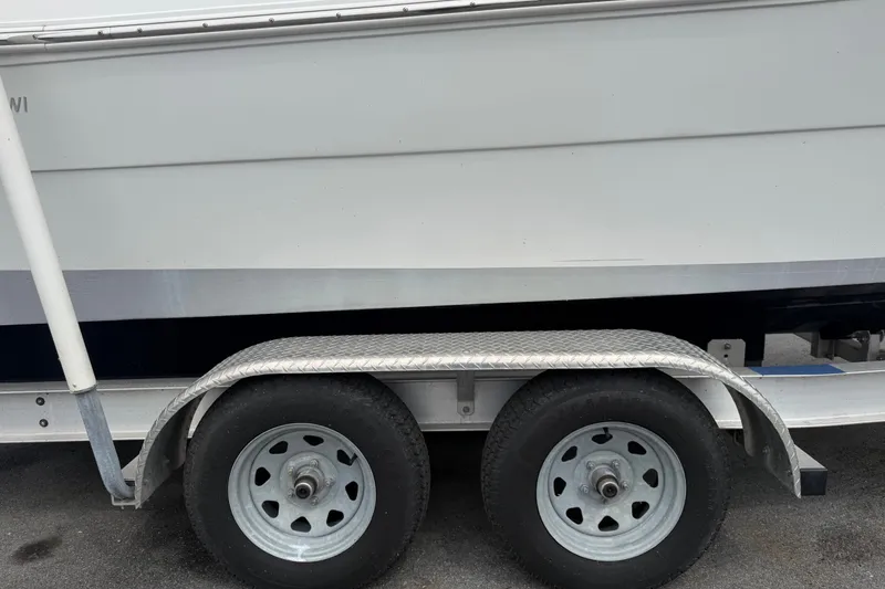 Slide: The Image of 2021 Key Largo 2650WI boat on a dual-axle trailer, side view. - 23