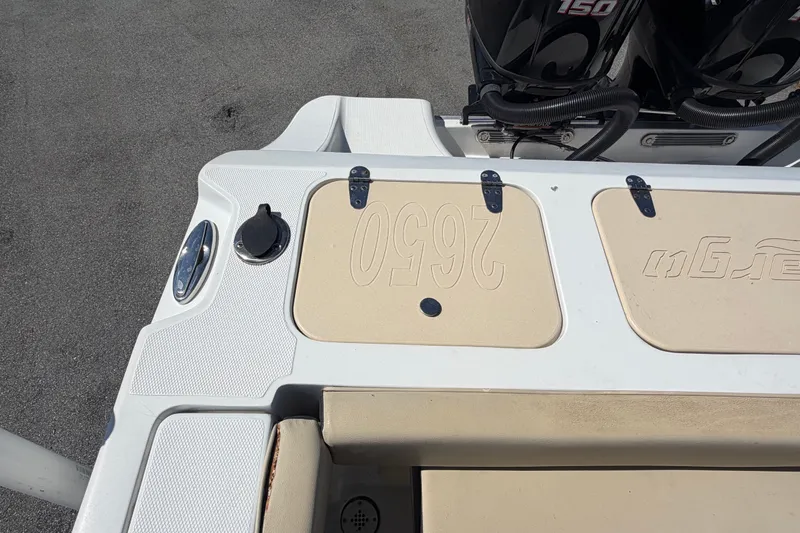 Slide: The Image of 2021 Key Largo 2650WI boat deck with storage compartments and dual outboard motors. - 76