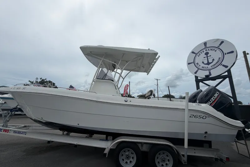Slide: The Image of 2021 Key Largo 2650WI boat on trailer, displayed at a dealership with a cloudy sky backdrop. - 5