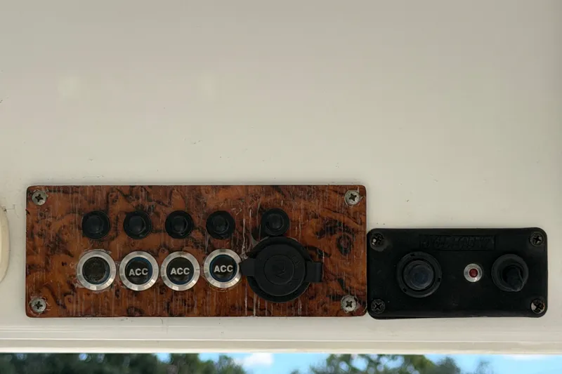 Slide: The Image of Control panel of a 2021 Key Largo 2650WI boat with accessory switches. - 27