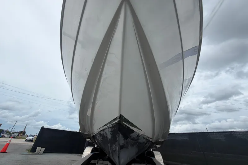 Slide: The Image of 2021 Key Largo 2650WI boat hull, viewed from below against a cloudy sky. - 8