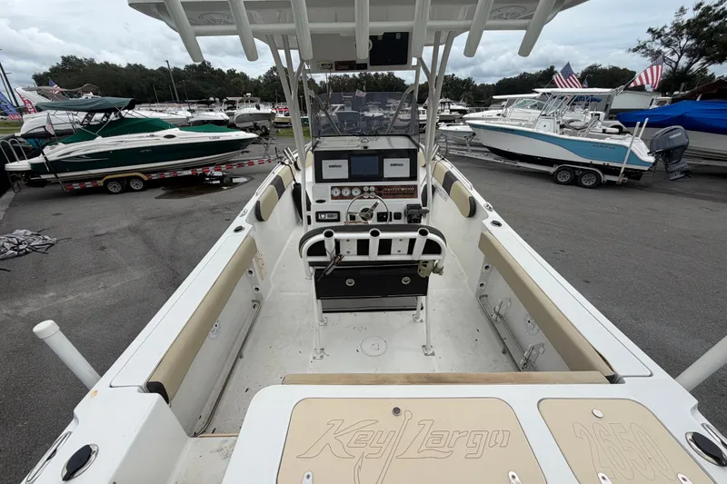 Slide: The Image of 2021 Key Largo 2650WI boat interior with control panel, docked among other boats. - 9
