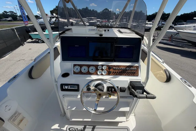 Slide: The Image of 2021 Key Largo 2650WI boat dashboard with steering wheel and navigation controls. - 24