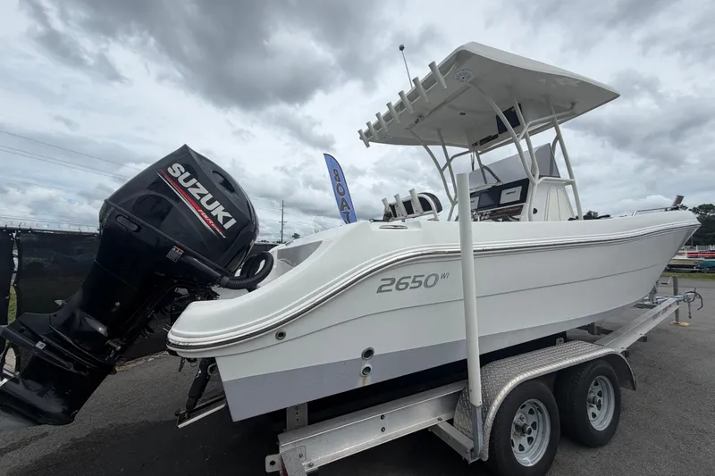 Slide: The Image of 2021 Key Largo 2650WI boat with Suzuki outboard motor on trailer. - 2