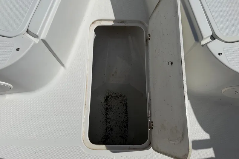 Slide: The Image of An open storage compartment on a boat with a white deck. - 44