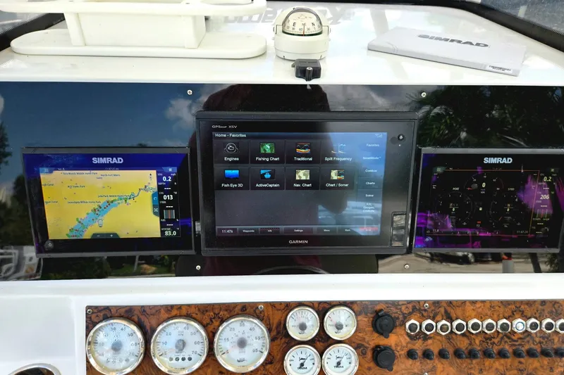 Slide: The Image of Dashboard of a 2021 Key Largo 2650WI boat with Simrad and Garmin displays. - 13