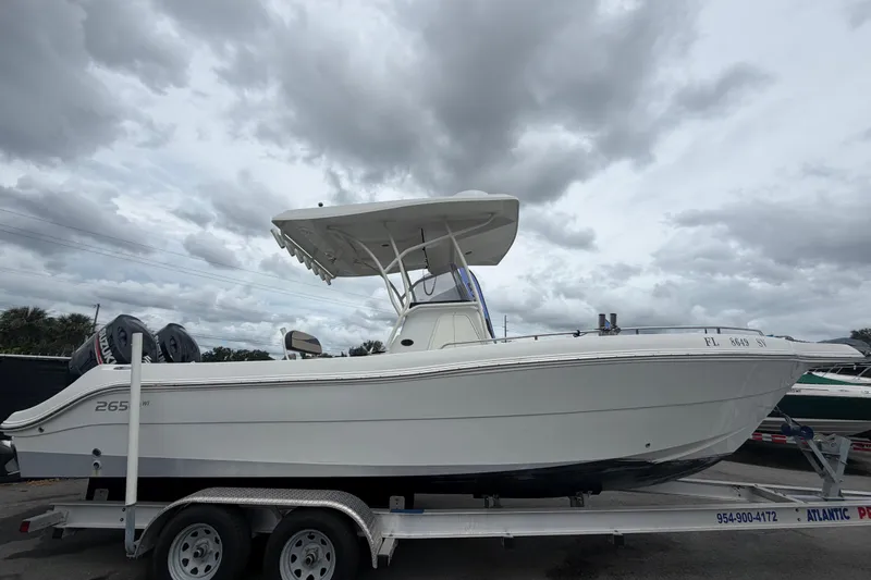Slide: The Image of 2021 Key Largo 2650WI boat on trailer under cloudy sky. - 1