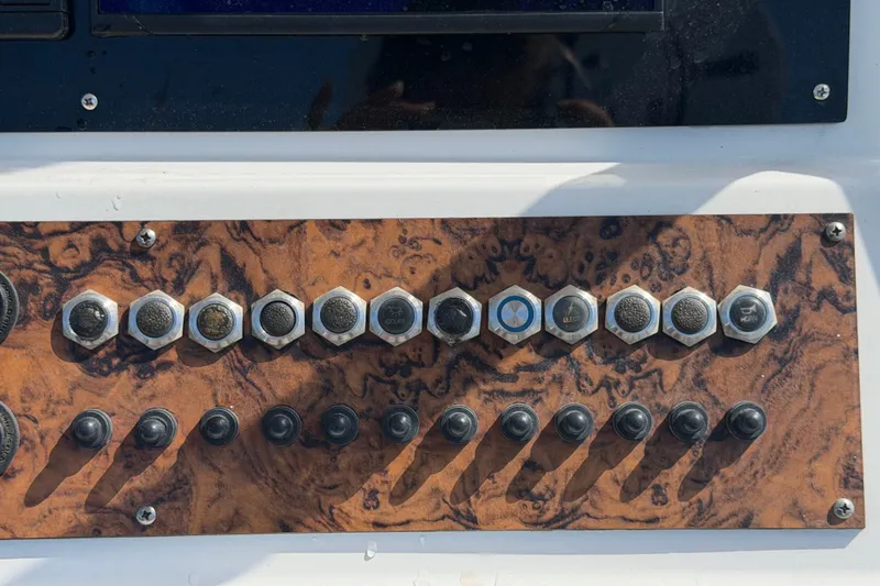 Slide: The Image of Control panel of a 2021 Key Largo 2650WI boat with switches and buttons. - 37