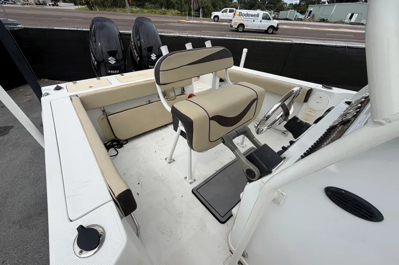 Slide: The Image of 2021 Key Largo 2650WI boat interior with dual Suzuki engines and beige seating. - 17