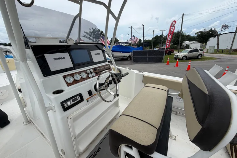Slide: The Image of 2021 Key Largo 2650WI boat dashboard with Simrad electronics and comfortable seating. - 11