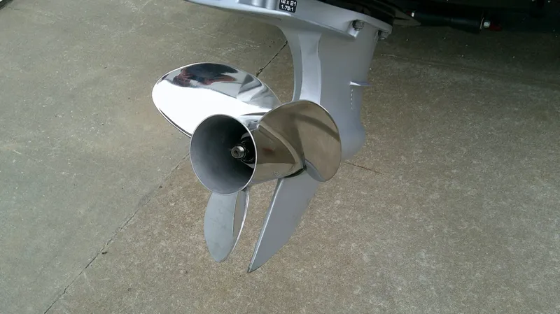 Slide: The Image of Close-up of a shiny propeller on a boat motor, mounted on a concrete floor. - 6