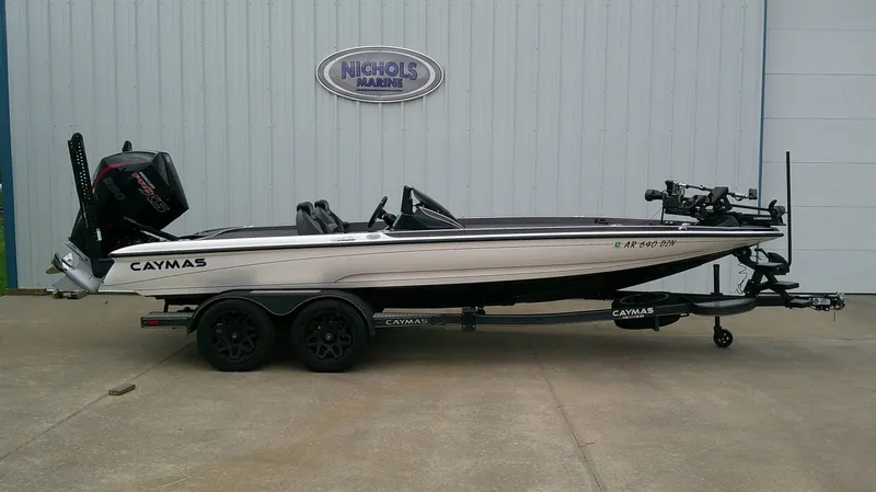 Slide: The Image of A 2025 Caymas CX 21 PRO boat on a trailer in front of a building. - 1