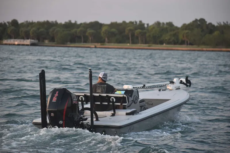 Slide: The Image of 2021 V-Tech 18 Flats boat cruising on a scenic waterway with lush greenery. - 6
