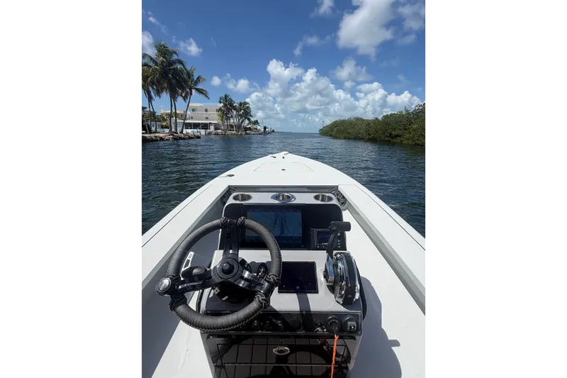 Slide: The Image of Steering console of a 2021 V-Tech 18 Flats boat on a sunny waterway. - 3