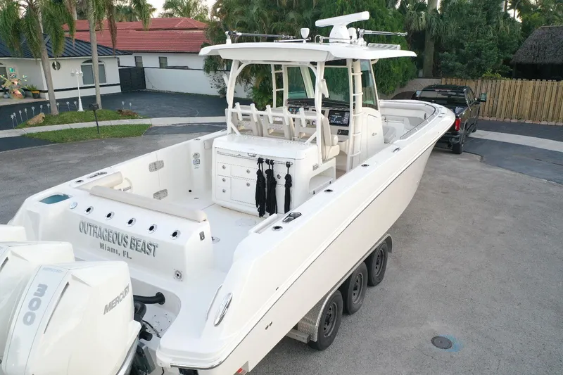 Slide: The Image of 2021 Boston Whaler 350 Outrage boat docked, rear view, with triple Mercury engines. - 10