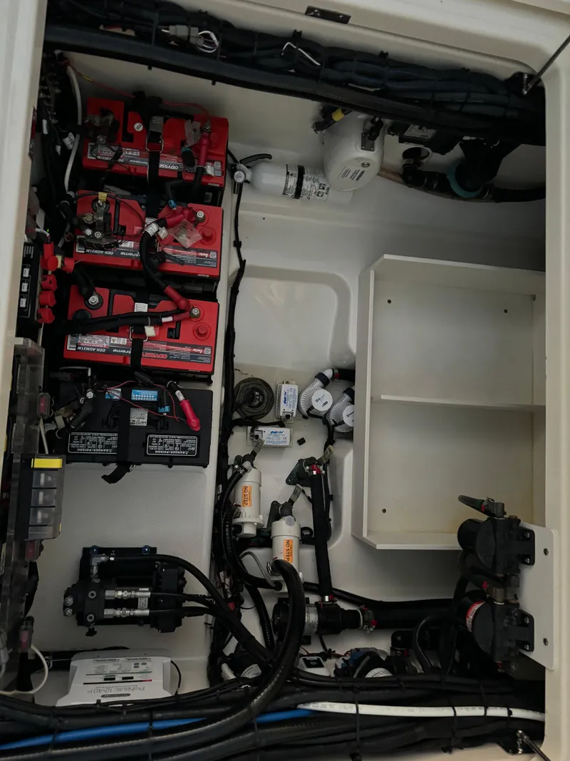 Slide: The Image of 2021 Boston Whaler 350 Outrage engine compartment with batteries and wiring. - 32