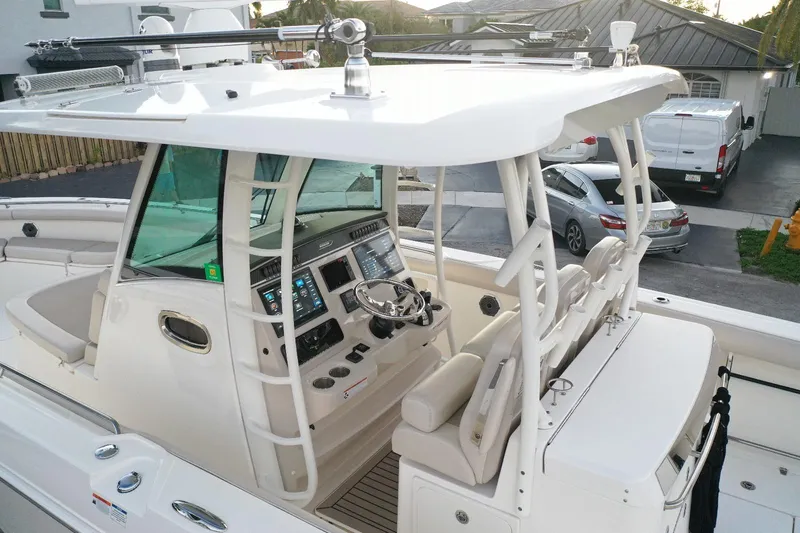 Slide: The Image of 2021 Boston Whaler 350 Outrage boat cockpit with advanced navigation controls and seating. - 19