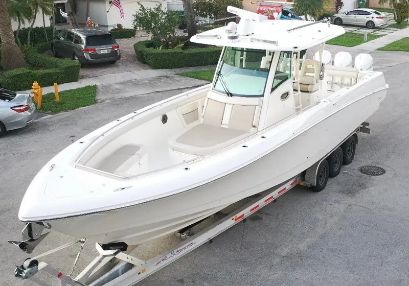 Slide: The Image of 2021 Boston Whaler 350 Outrage boat on a trailer in a residential area. - 1