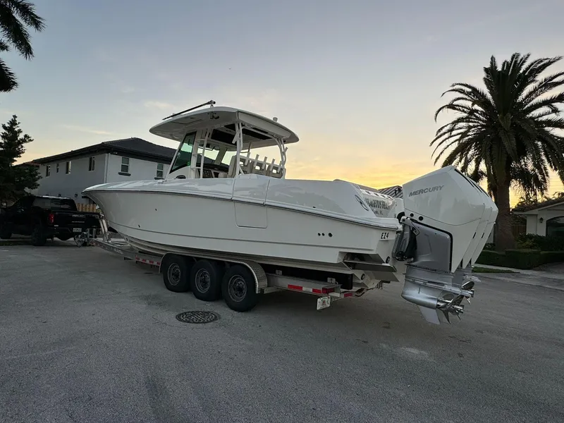 Slide: The Image of 2021 Boston Whaler 350 Outrage boat on a trailer at sunset. - 8