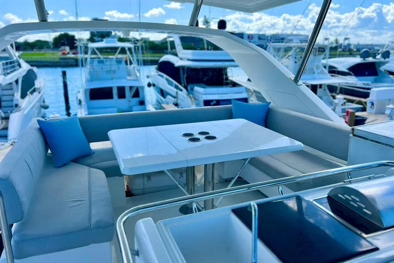Slide: The Image of Aquila 44 Yacht 2020, luxurious deck seating with table, marina view. - 2