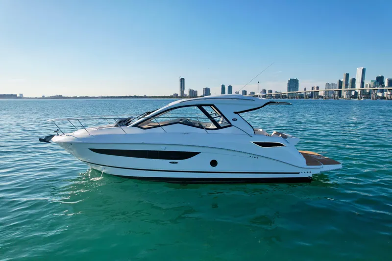 Slide: The Image of 2018 Sea Ray 350 DAC yacht on calm water with city skyline in background. - 1
