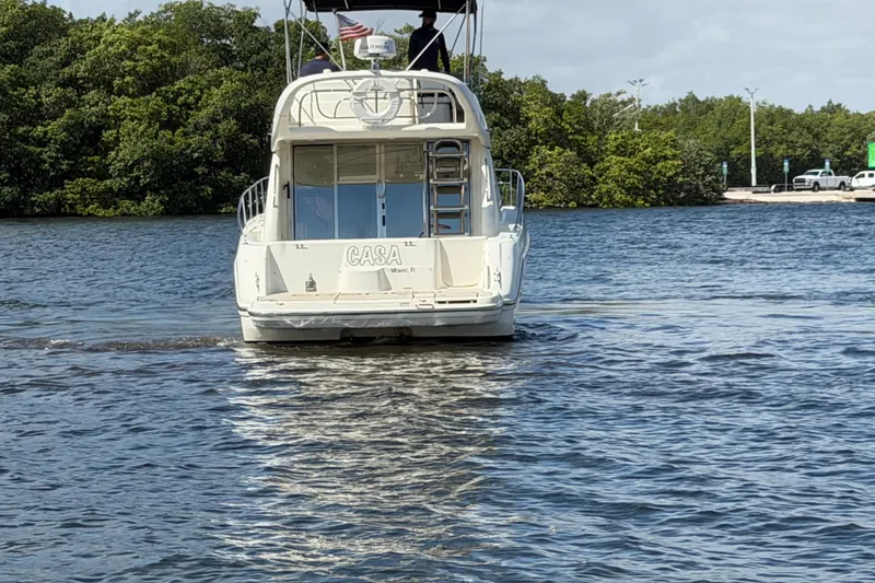 Slide: The Image of 2007 Cranchi Atlantique 40 yacht cruising on a calm river with lush greenery. - 2