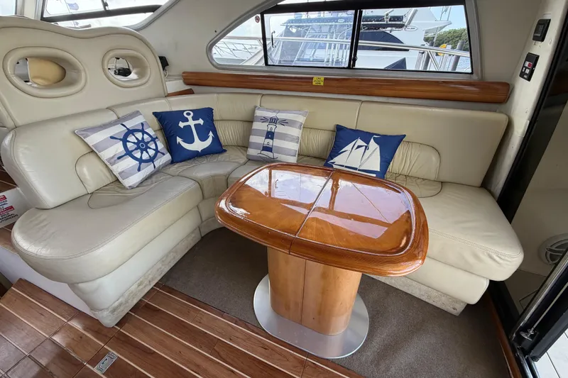 Slide: The Image of Luxurious 2007 Cranchi Atlantique 40 yacht interior with nautical-themed cushions and elegant wooden table. - 13