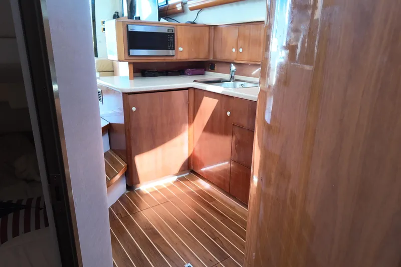 Slide: The Image of Interior of 2007 Cranchi Atlantique 40 yacht with wooden cabinetry and modern kitchen amenities. - 21