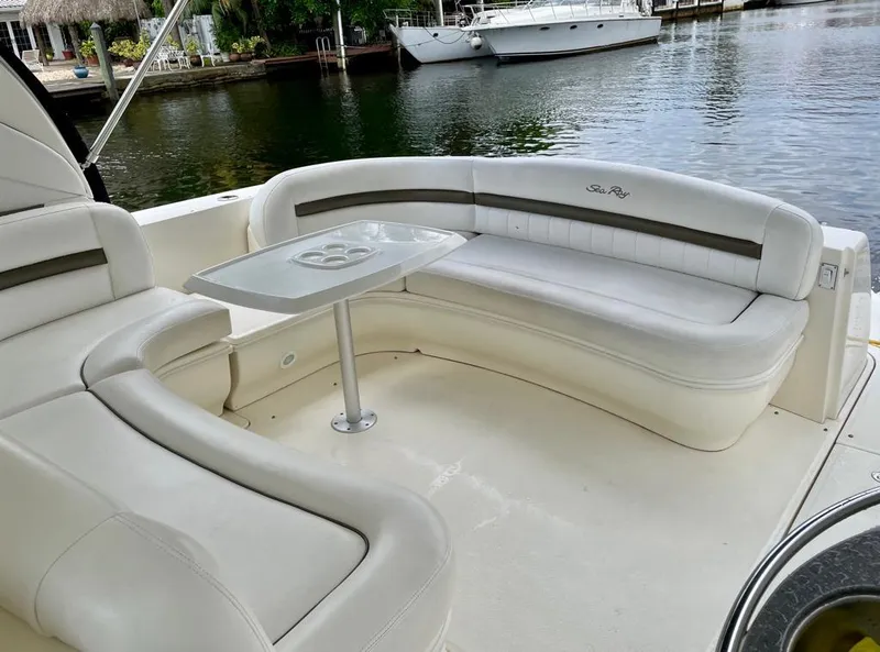 Slide: The Image of 2007 Sea Ray 44 Sundancer boat with white leather seating and table on deck. - 13
