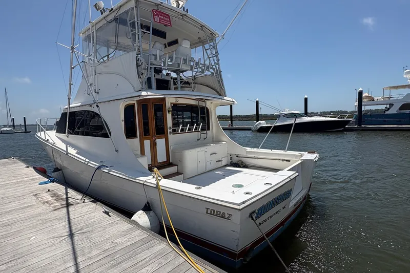Slide: The Image of 1989 Topaz 44 Sportfisherman yacht docked at marina under clear blue sky. - 2