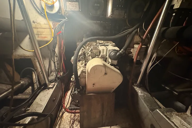 Slide: The Image of Engine room of 1989 Topaz 44 Sportfisherman, showcasing mechanical components and wiring. - 27