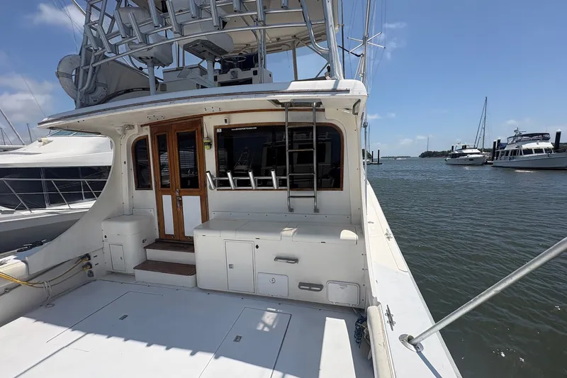 Slide: The Image of 1989 Topaz 44 Sportfisherman yacht docked at marina, featuring spacious deck and fishing equipment. - 3