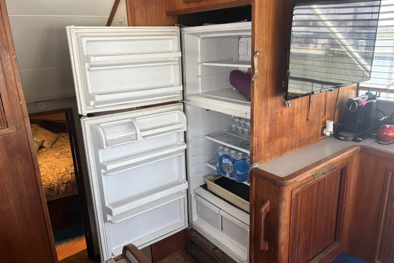 Slide: The Image of Open refrigerator in 1989 Topaz 44 Sportfisherman yacht interior, with wooden cabinetry and countertop. - 24