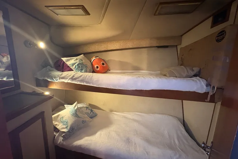 Slide: The Image of Cozy bunk beds in 1989 Topaz 44 Sportfisherman cabin with plush pillows and soft lighting. - 14