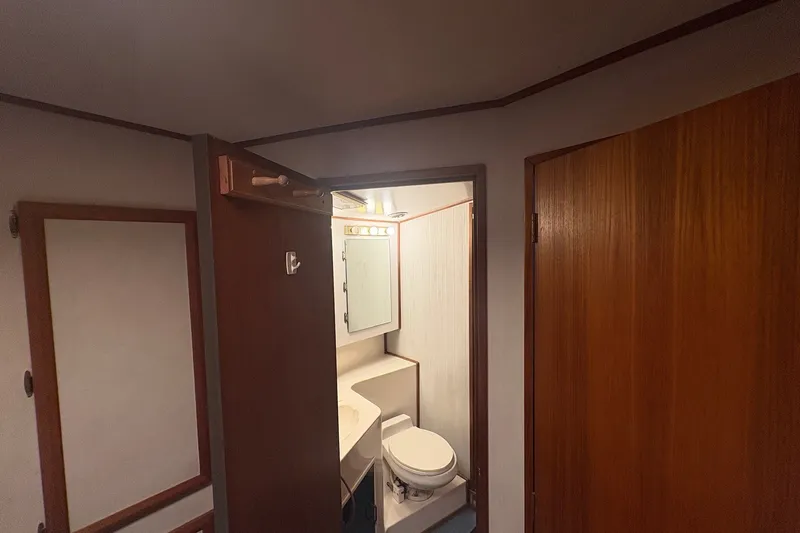 Slide: The Image of Interior view of 1989 Topaz 44 Sportfisherman bathroom with wooden doors and compact design. - 20