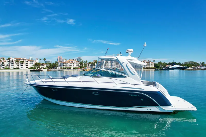 Slide: The Image of 2006 Formula 40pc yacht on clear blue water, with a scenic coastal backdrop. - 1