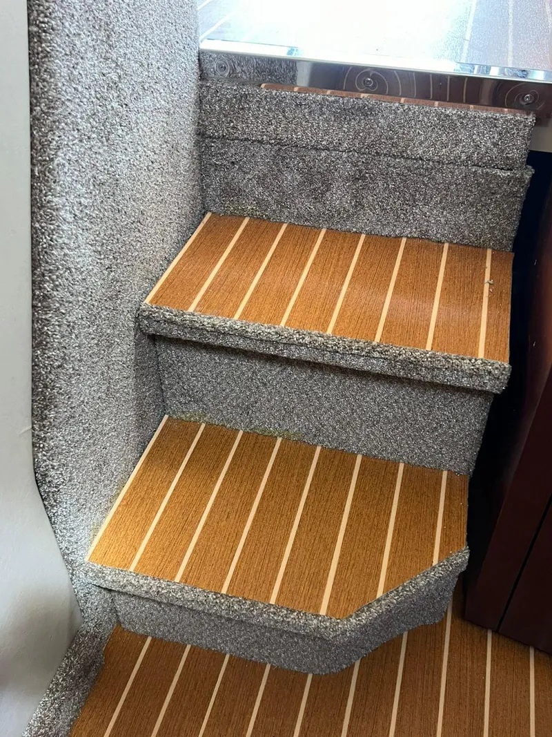 Slide: The Image of Wooden steps with carpeted sides in a 2006 Formula 40pc boat interior. - 28