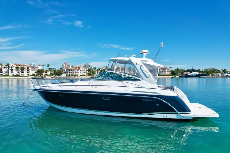 Slide: The Image of 2006 Formula 40pc yacht on clear blue water, sunny day, coastal background. - 2