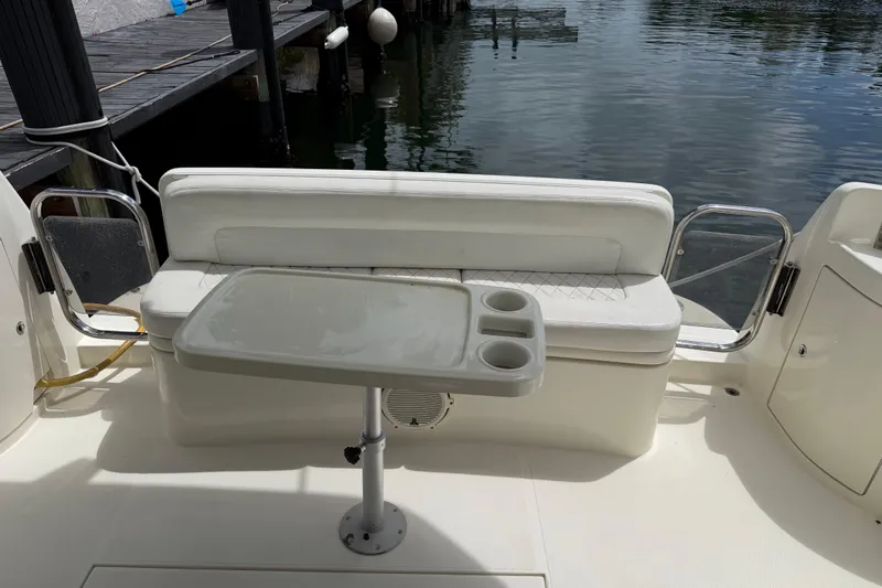 Slide: The Image of 2004 Azimut 39E yacht seating area with table and cup holders by the water. - 10