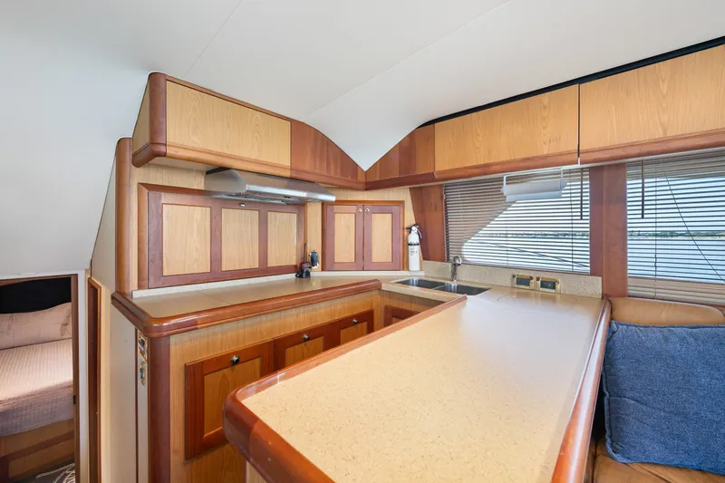 Slide: The Image of Luxurious 2005 Luhrs 41 Convertible yacht interior with modern kitchen and wooden cabinetry. - 11